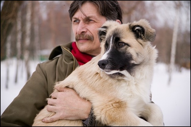 Man holding dog in arms snowy